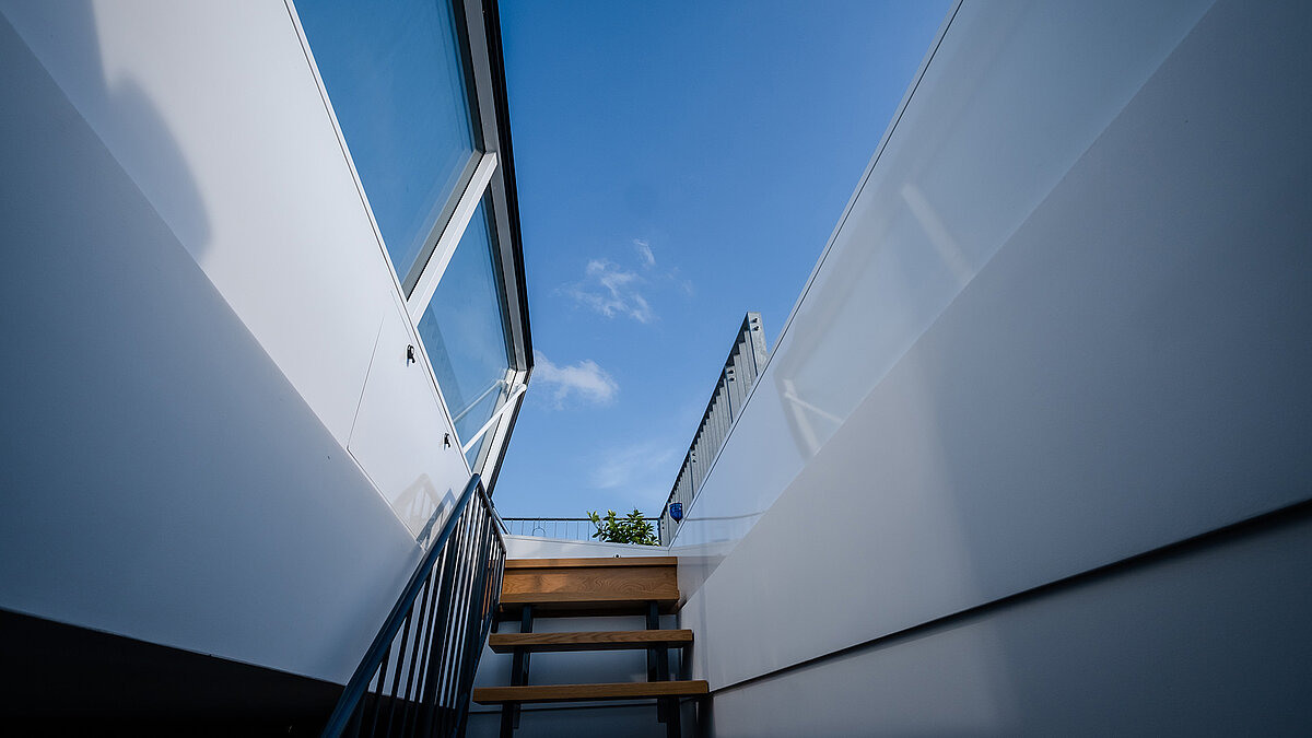 Blick von innen auf den Flachdach-Ausstieg eines Townhouses in Berlin mit blauem Himmel im Hintergrund.