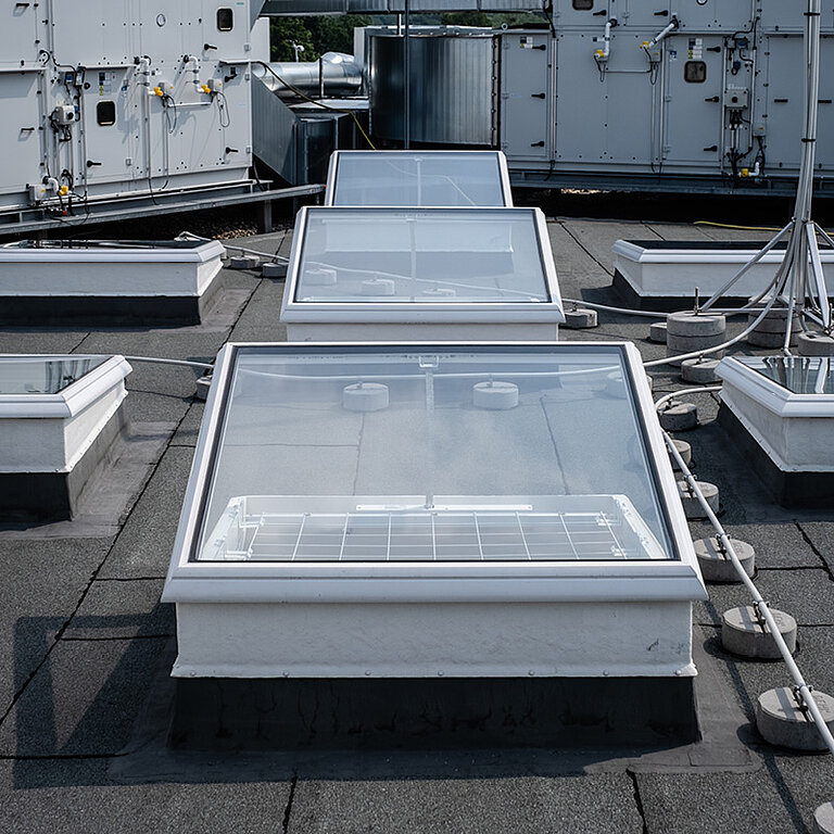 Mehrere LAMILUX Flachdach Fenster F100 RWA auf Industrie-Flachdach in Reihenanordnung