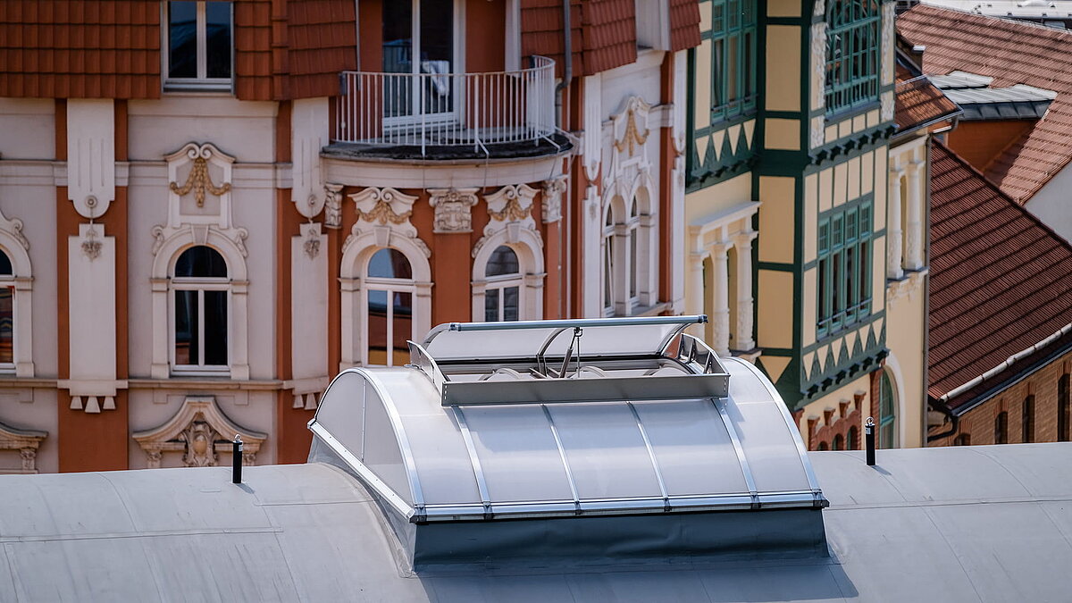 Dach der Kletterhalle "Alte Brauerei" in Eisenach mit LAMILUX Lichtband B, umgeben von historischen Fassaden.