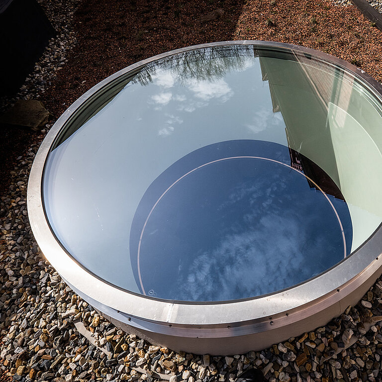 LAMILUX Flachdach Fenster FE rund auf Flachdach mit Kies, Außenansicht mit Spiegelung des Himmels