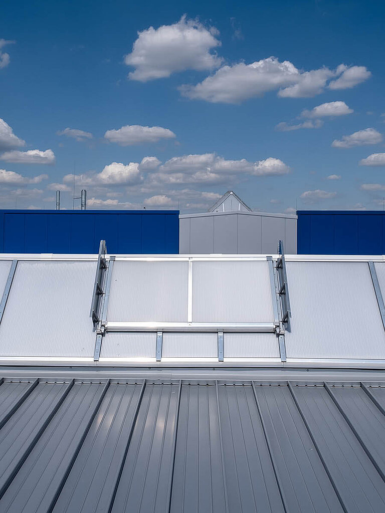 Geschlossenes LAMILUX Lichtband S RWA auf Industrie-Flachdach in Satteldachform mit transparenter Verglasung