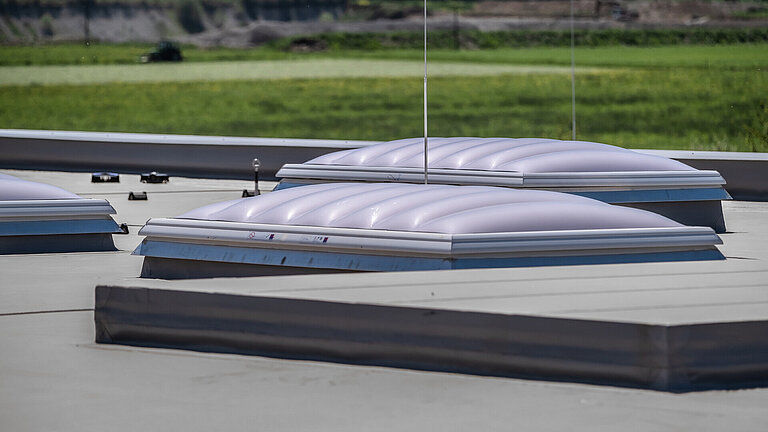 Mehrere LAMILUX Lichtkuppeln F100 W auf Flachdach zur Versorgung großer Flächen mit Tageslicht