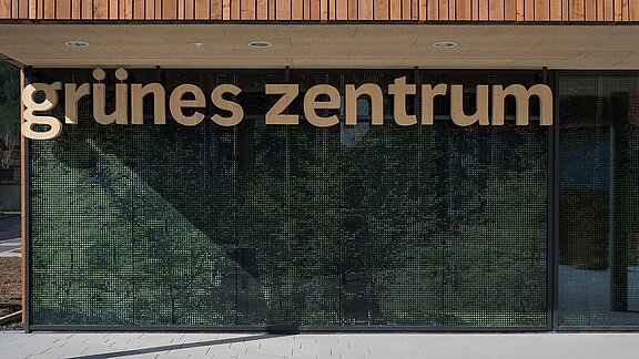  Eingangsbereich des Grünen Zentrums Immenstadt mit moderner Glasfassade und Holzschriftzug.