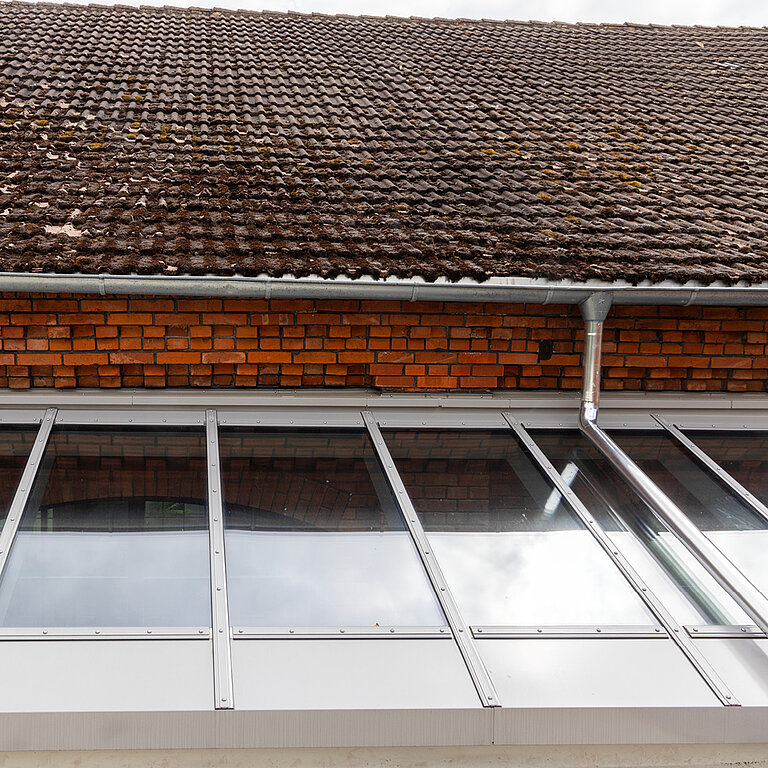 Glasdach Fire Resistance mit mehreren feuerbeständigen Elementen unter Ziegeldach.