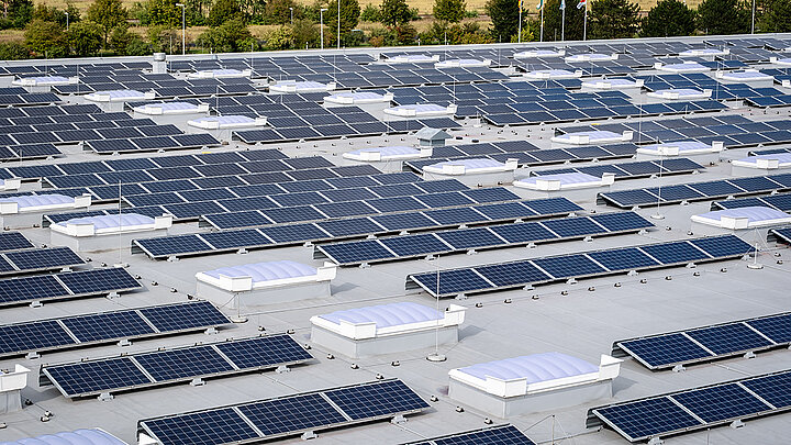 Industrieareal mit großflächiger Photovoltaikanlage und mehreren Lichtbändern auf Flachdächern