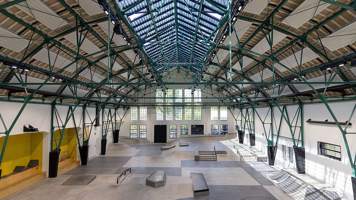 Innenraum einer ehemaligen Industriehalle mit LAMILUX Glasdach PR60 und integrierter Skateanlage.