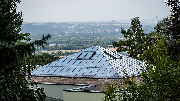 Außenansicht vom Glasdach im Zoo Neuwied mit PR60-Konstruktion umgeben von Bäumen mit Blick auf die Landschaft.
