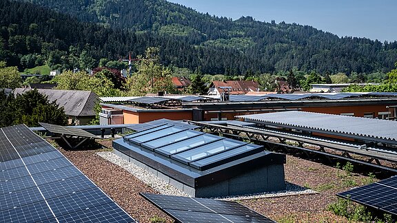 Modulares Glasdach von LAMILUX auf einem Wohnhaus in Freiburg, umgeben von Solarpanelen und einer grüner Landschaft.