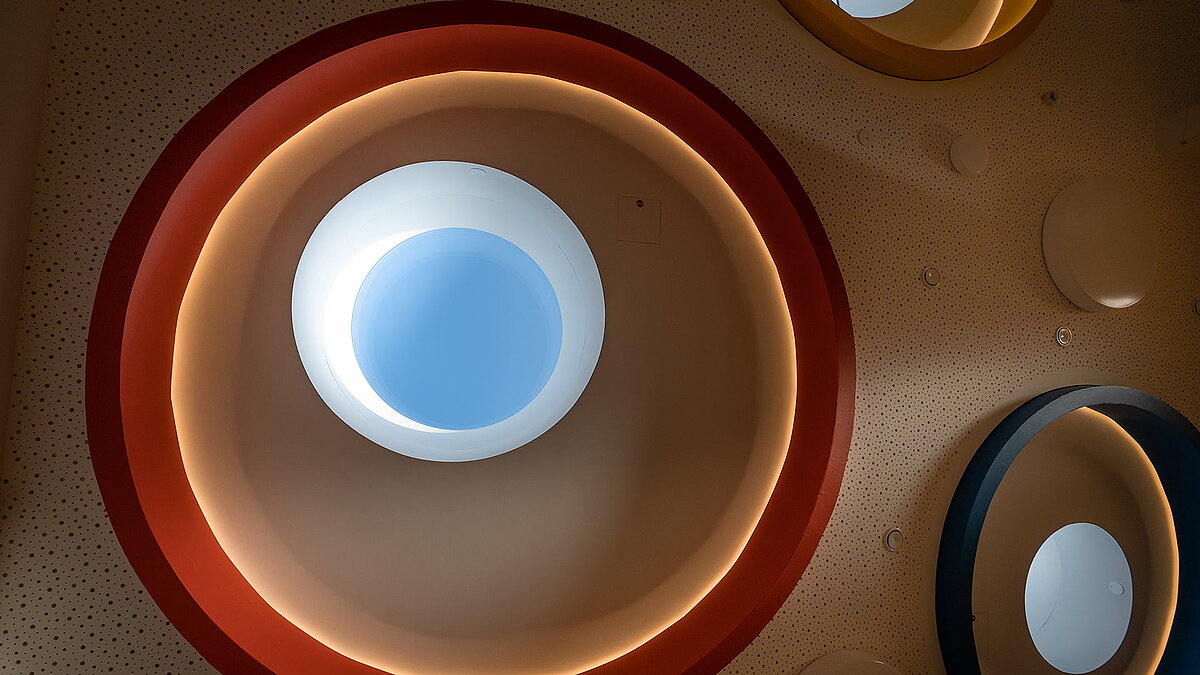 Detailansicht der runden Oberlichter mit farbigen Ringen und indirekter Beleuchtung in der Kindertagesstätte Glückliche Zukunft in Sömmerda.