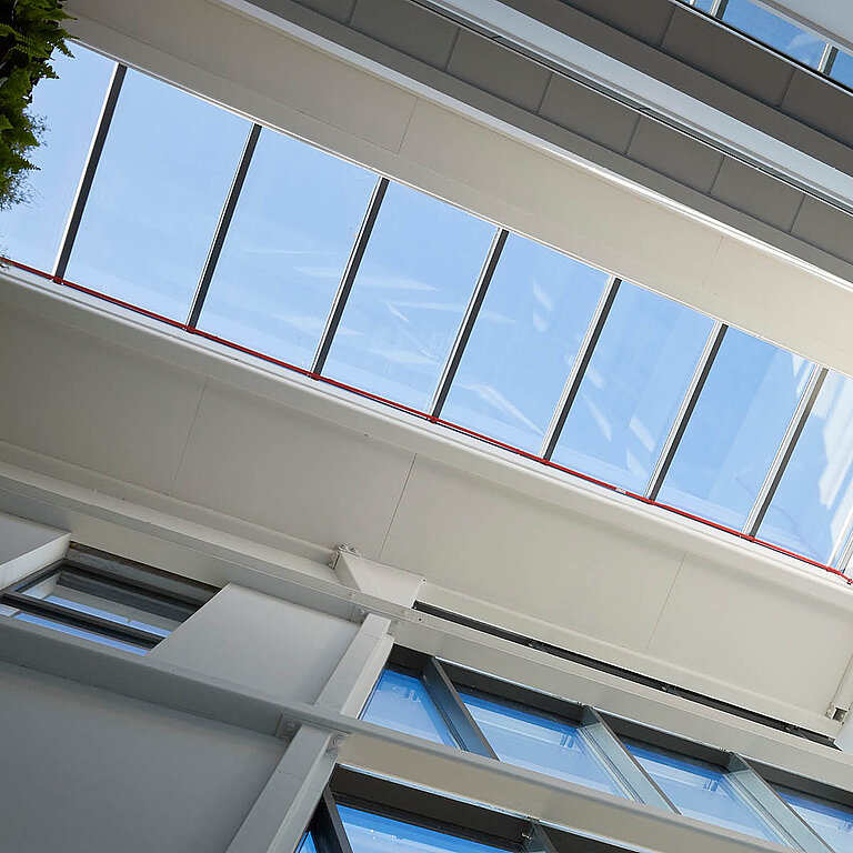 Langgezogenes Glasdach PR60 Passivhaus über einem lichtdurchfluteten Atrium.