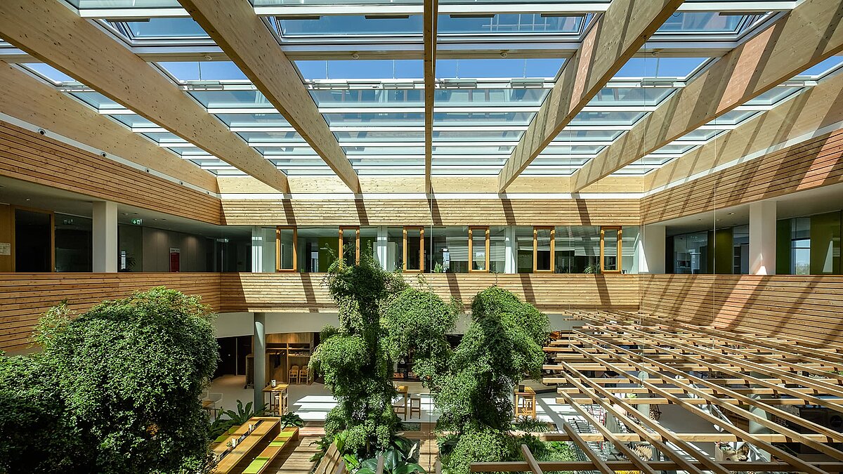 Lichtdurchflutetes Atrium des Naturkostladens Byodo in Mühldorf mit großen Glasdachflächen und grüner Innenbepflanzung.