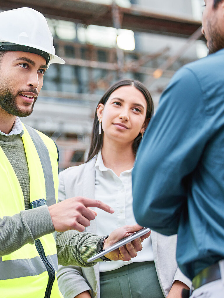 Beratungsgespräch auf der Baustelle mit Bauleiter und Team