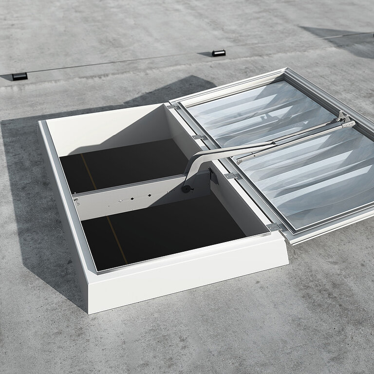 Geöffnete LAMILUX Lichtkuppel RWA auf Flachdach mit rechteckigem Aufsatzrahmen, transparenter Verglasung und sichtbarer Öffnungsmechanik zur Rauch- und Wärmeabführung