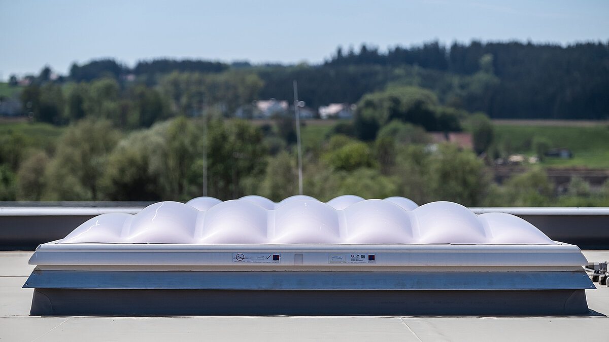 Nahaufnahme einer LAMILUX Lichtkuppel F100 W auf dem Dach der Produktionshalle des Bauunternehmens Unglehrt.