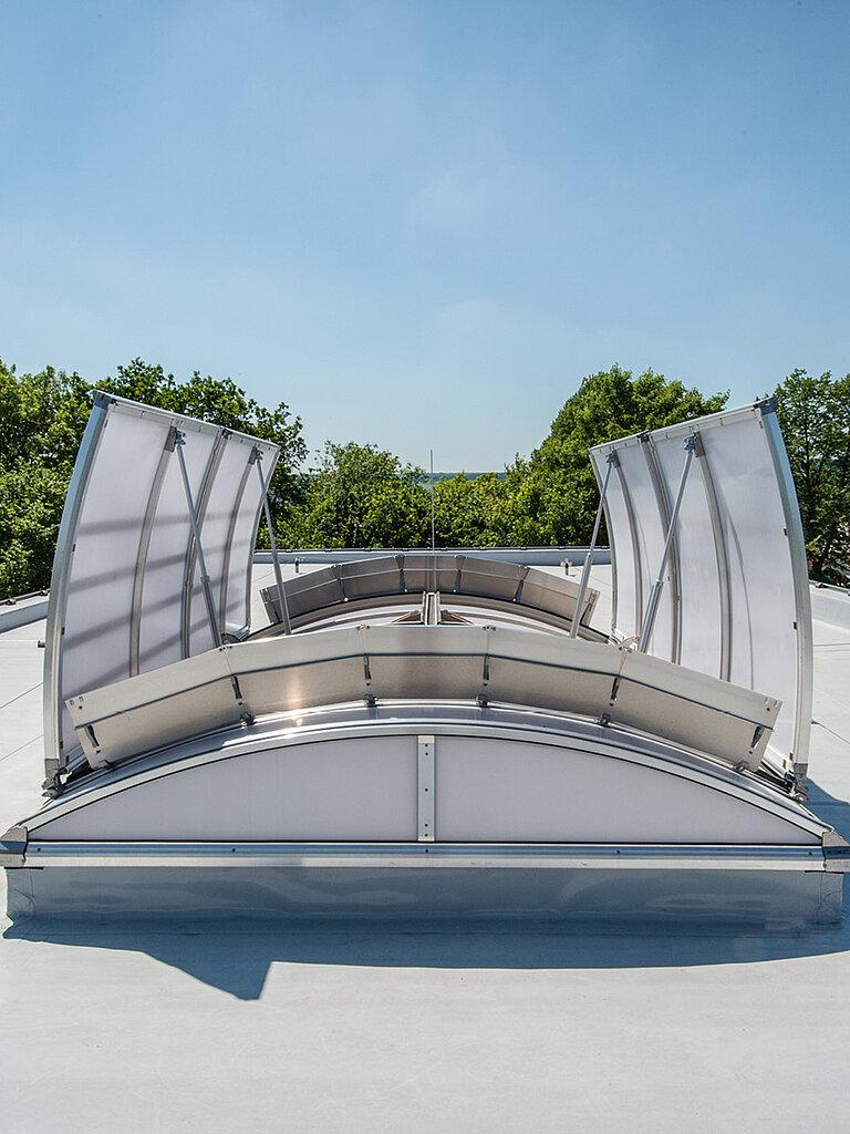 Geöffnete LAMILUX Brandschutzfenster mit feuerwiderstandsfähiger Verglasung auf Flachdach