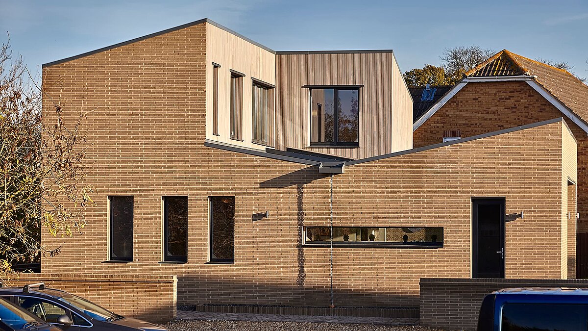 Modernes Gebäude der Potton Show Homes in England mit Holz- und Backsteinfassade und großen Fenstern.