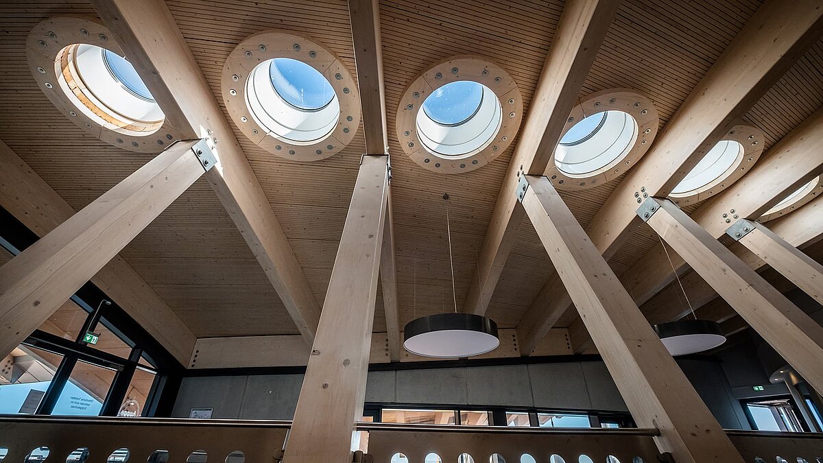 Innenansicht des Hafenterminals Norderney mit mehreren runden Flachdach Fenstern und Holzbalken.