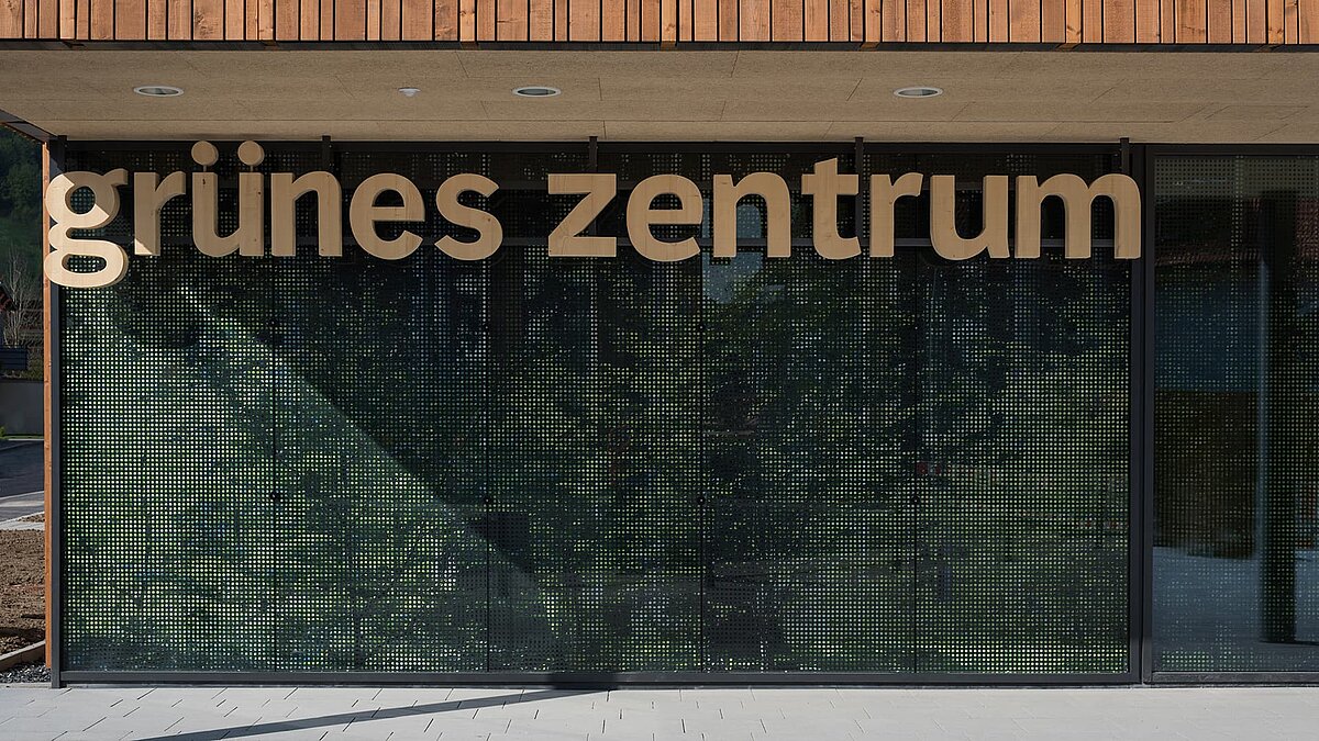 Eingangsbereich des Grünen Zentrums Immenstadt mit moderner Glasfassade und Holzschriftzug.