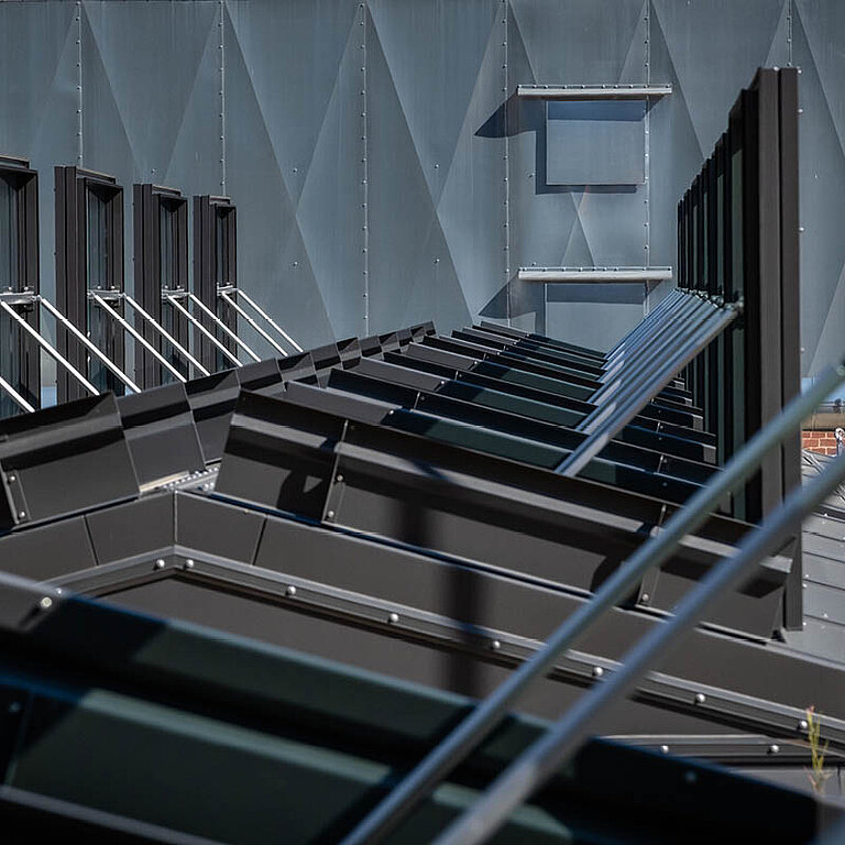 Mehrere geöffnete LAMILUX Glasdach RWA mit geneigter Verglasung und Metalltragkonstruktion in Industrie- oder Atriumbereich