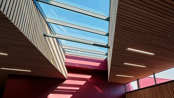 Innenansicht der Sheffield Hallam University mit LAMILUX Glasdach PR60 und modernen Holzdecken.