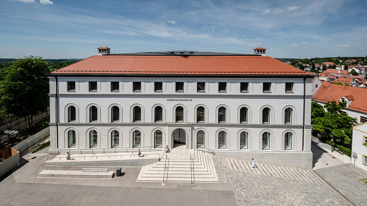 Frontansicht des Diözesan Museums in Freising. Es handelt sich um ein breites graues Haus