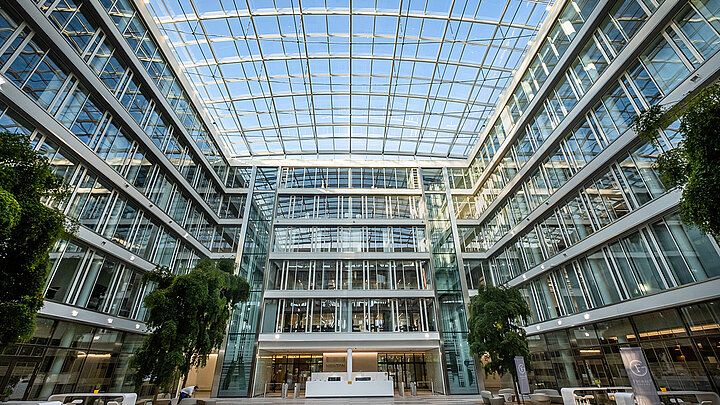 Helles Atrium eines modernen Bürogebäudes mit großem Glasdach