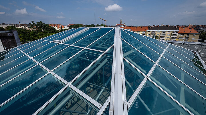 Vogelperspektive auf das Glasdach des Dante Gymnasiums in München LAMILUX Glasdach PR60 über Aula eines Gymnasiums | insights by LAMILUX