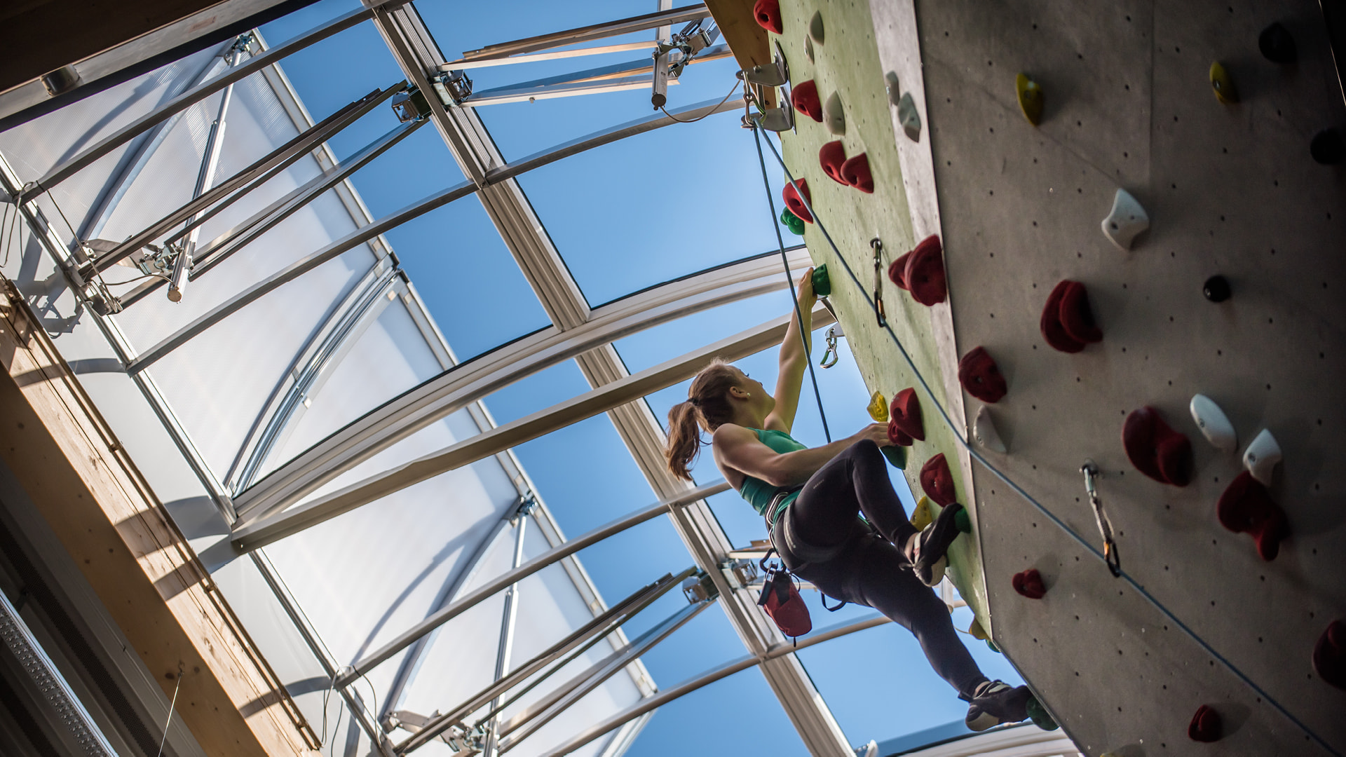 Frau an einer Kletterwand unter einem LAMILUX Lichtband