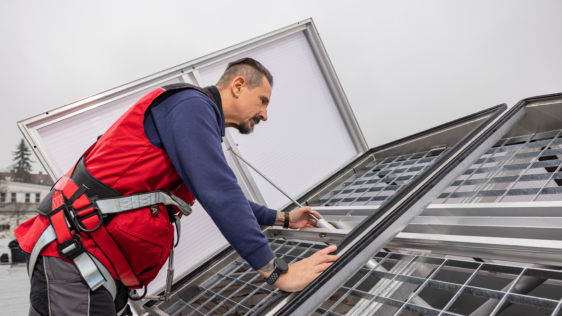 Handwerker montiert ein Tageslichtelement auf einem Flachdach